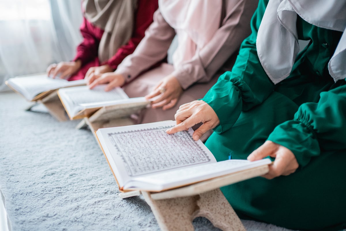 Three Young Women Wearing Hijabs Read the Holy Book of the Al-Quran Together